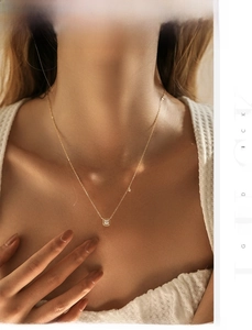 Close-up of elegant 18K gold square zircon pendant necklace worn by a female model