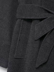 Macro detail of charcoal grey wool coat showing belt knot and high-density twill texture