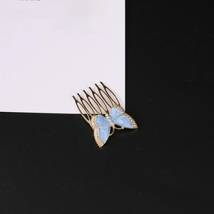 Elegant gold metal butterfly hair comb with blue enamel and sparkling rhinestones