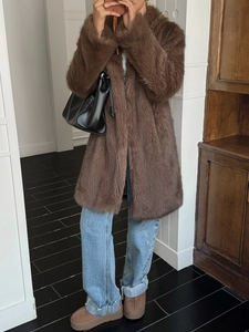 Manteau en fausse fourrure marron tendance avec jean bleu clair et bottes plateforme