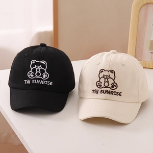 Detail of embroidered cartoon bear and Till SUNRISE text on cotton baseball caps