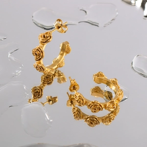 Vintage 18K gold-plated hoop earrings with embossed rose pattern on reflective surface
