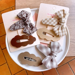 Detailed set of floral bow hairpins and cloud-shaped clips on a display card