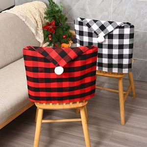 Detail of red and white buffalo plaid Christmas chair covers with white pom-poms