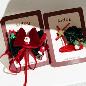 Close-up of Christmas velvet bow hair clips with Santa Claus and bell ornaments