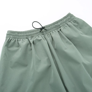 Dettaglio dei pantaloni cargo retrò a vita alta con elastico in vita e coulisse con fibbia nera