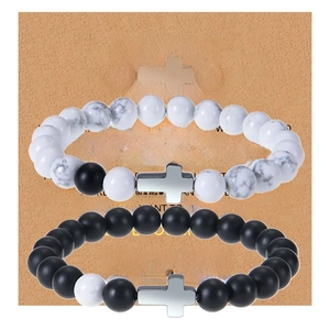 Close-up of matte black beads and white turquoise cross bracelets on a gift card