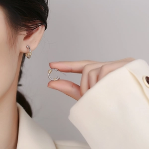 S925 sterling silver hoop earrings with gold floral texture on a soft background