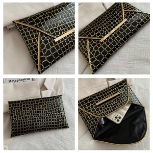 Detailansicht der schwarzen Umschlag-Clutch mit Krokoprägung und goldener V-Verzierung