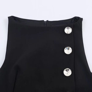Sleeveless black top with round neck featuring three large sparkling rhinestone buttons