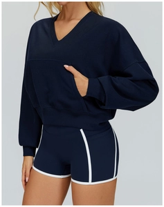 Detail of navy hooded sports top featuring white contrast trim and large kangaroo pocket