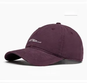 Dettaglio del ricamo bianco su un cappellino da baseball in cotone lavato viola scuro
