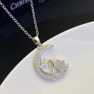 Detail of silver moon pendant with sparkling zircons and inner heart star design