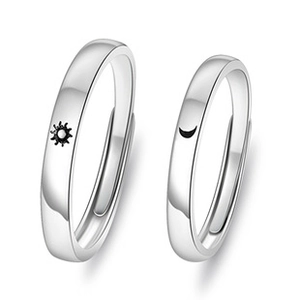 Detail of silver sun and moon couple rings showing the delicate metal texture