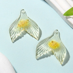 Macro view of transparent resin mermaid tails with yellow glitter for jewelry making