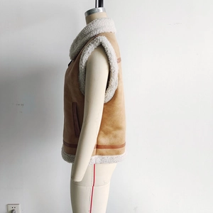 Detailed side view of camel faux suede vest with warm white faux shearling lining and trim