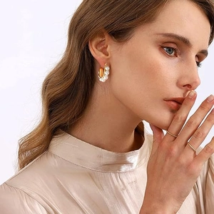 U-shaped 18K gold stainless steel earrings with white pearls on a female model