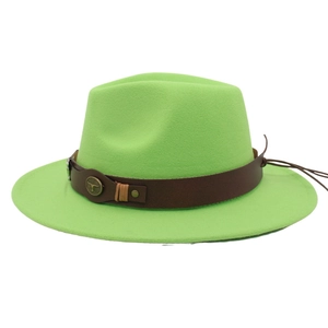 Détail d'un chapeau fedora vert avec une bande en cuir et un emblème de taureau en métal