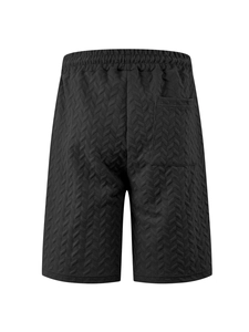 Detail view of black waffle knit fabric and drawstring waistband on men's beach shorts