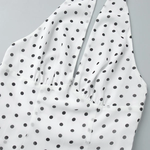 Detailed shot of white polka dot top with ruched bodice and V-neckline texture