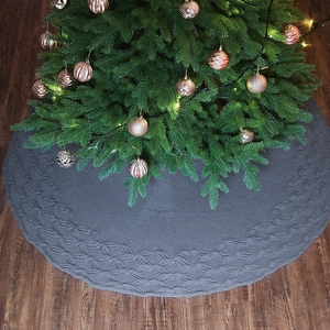 Dark grey knitted Christmas tree skirt with thick cable knit texture and scalloped edges