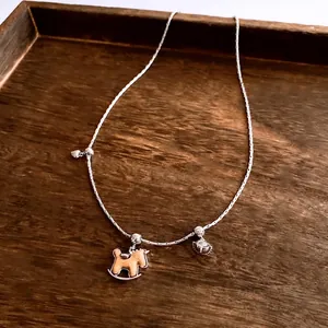 Collier minimaliste avec pendentif cheval de bois et chaîne argentée sur plateau bois