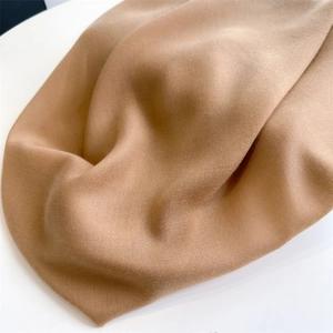 Close-up of soft khaki linen fabric texture and elegant drape of a women's square shawl