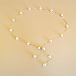 Close-up of elegant pearl waist chain with golden chain link and delicate pearl pendants