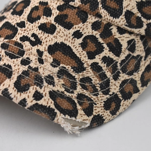 Detail of frayed edges and stitching on washed leopard print ponytail baseball cap
