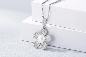 Detail of silver daisy flower pendant with sparkling rhinestones and white pearl center