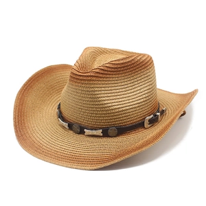 Detail of hand-woven straw cowboy hat with leather band and star metal studs decoration