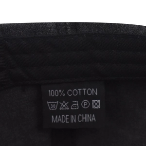 Macro view of 100% cotton washing label and internal stitching on black baseball cap