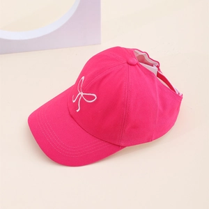 Détail de la visière rose pour enfants avec broderie de nœud blanc sur le devant