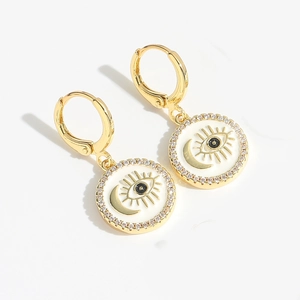 Close-up of golden Evil Eye and Moon drop earrings with sparkling cubic zirconia accents