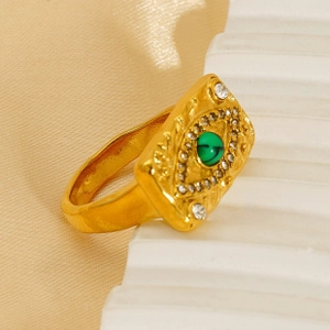 Macro shot of gold-plated evil eye ring with green stone and pavé zircon details