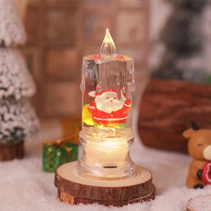 Close-up of lighted LED Christmas candle with Santa Claus figure and sparkling glitter
