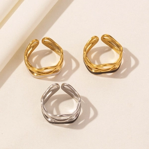Three wave open stainless steel rings in black and white enamel finish with golden accents