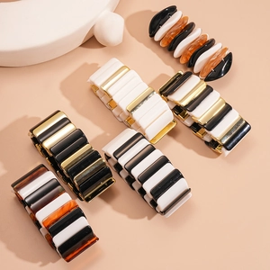 Macro shot of colorful acrylic and gold plated stretch geometric bracelets for women
