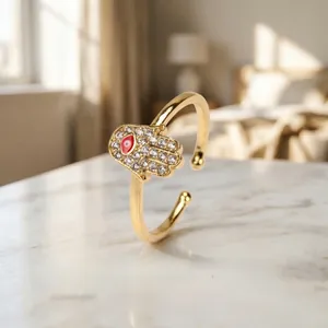 Detailed shot of Hamsa hand ring with red evil eye and white zircon inlay on marble