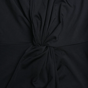 Détail du nœud torsadé sur une robe noire élégante à manches longues et décolleté en V