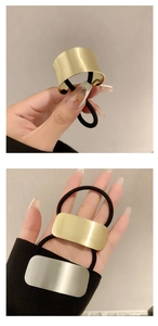 Detail of minimalist gold and silver metallic brushed hair ties for ponytail styling