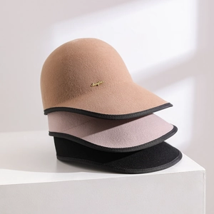 Detail of wool felt equestrian caps in three colors with gold metal logo accents