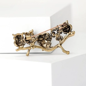 Close-up of the vintage owl brooch back showing the bronze metal pin and clasp mechanism