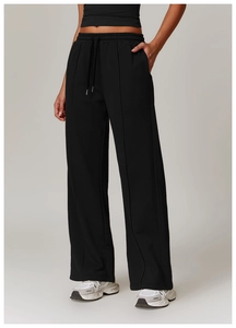 Detail of high-waist joggers showing drawstring waistband and vertical front seams