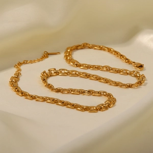 Gros plan détaillé d'un bracelet gourmette en acier titane plaqué or 18 carats