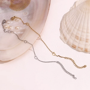 Detail of interlocking heart pendants on delicate gold and silver stainless steel chains