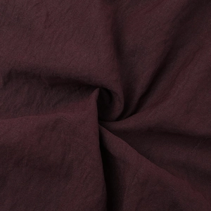 Macro shot of dark burgundy cotton linen fabric texture for summer short sleeve romper