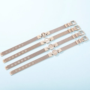 Rose gold mesh bracelet set with crown and tree of life charms on blue background