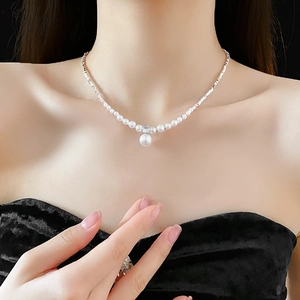Elegant white faux pearl necklace with large pearl pendant shown on a model neck