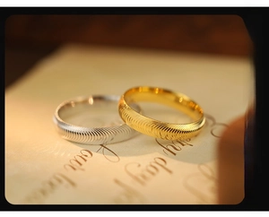Macro shot of minimalist gold and silver rings with textured fingerprint patterns
